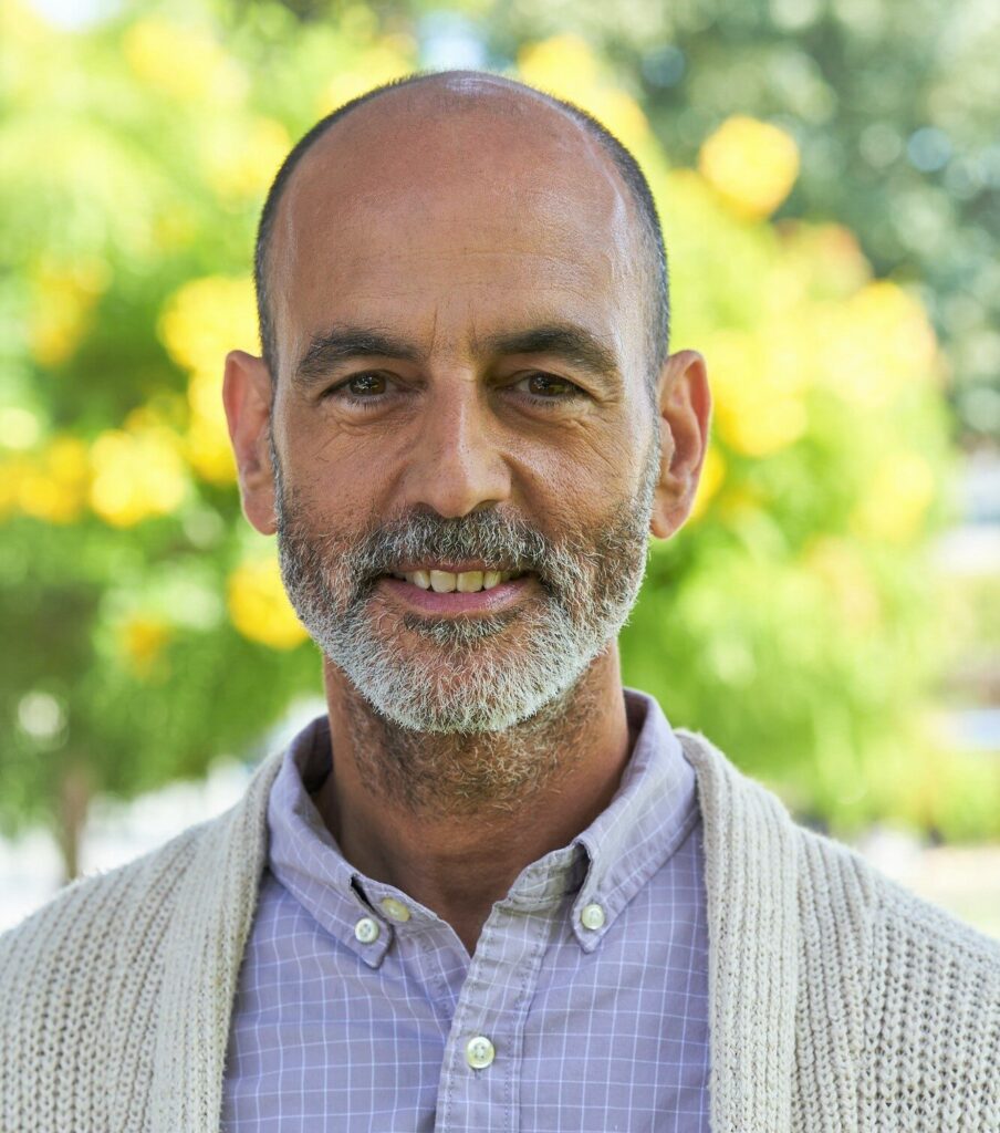 Dr. Matthew Silverstein standing outside with a green lush background