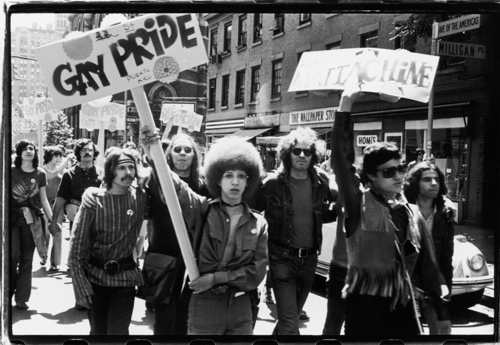 Christopher Street Liberation Day, 1970. People hold 'Gay Pride' and 'Mattachine' signs during the first Stonewall anniversary march. In 2026, if you are having mixed feelings about Pride, you are not alone.